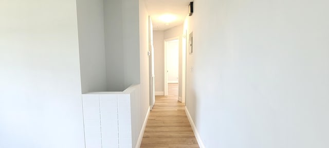 hallway with light hardwood / wood-style floors