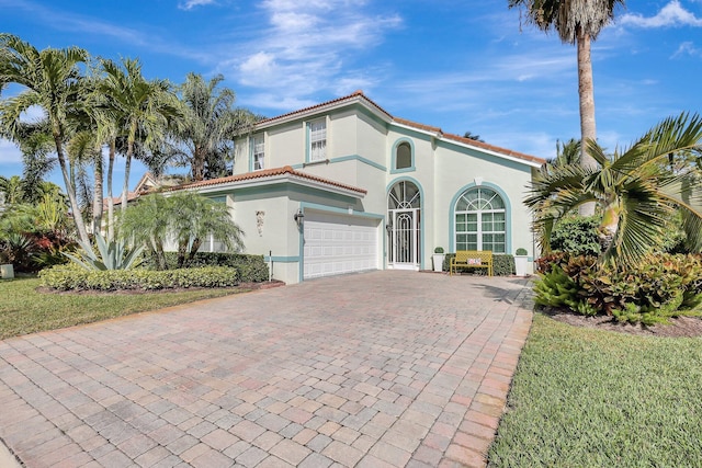 mediterranean / spanish house featuring a front lawn and a garage