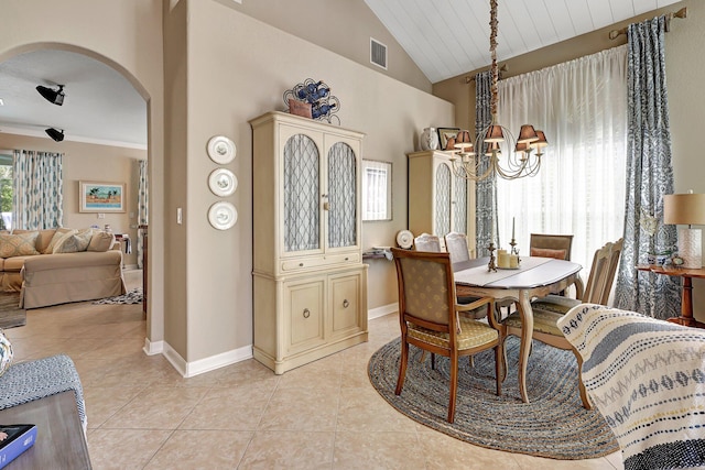 dining area with visible vents, arched walkways, an inviting chandelier, light tile patterned flooring, and vaulted ceiling