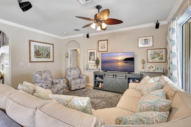 living room featuring visible vents, arched walkways, ceiling fan, and crown molding