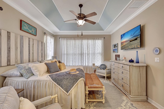 bedroom with visible vents, multiple windows, crown molding, and a raised ceiling