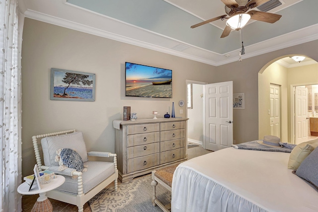 bedroom with ornamental molding, a ceiling fan, connected bathroom, arched walkways, and baseboards