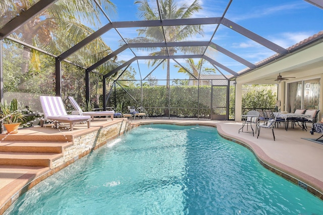 outdoor pool with a lanai, a patio, and ceiling fan