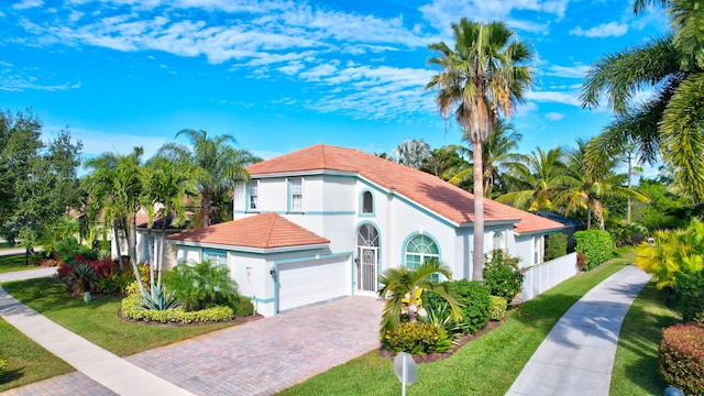 mediterranean / spanish-style house with a garage and a front lawn