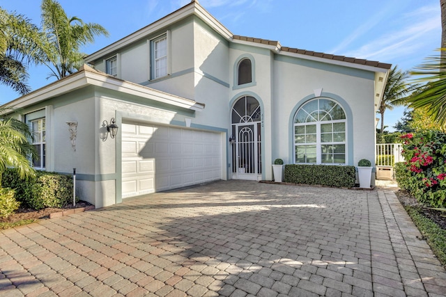 mediterranean / spanish home with stucco siding, decorative driveway, and a tile roof