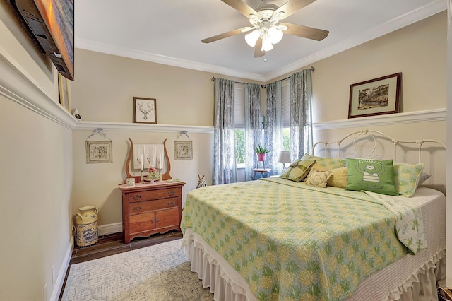 bedroom with ceiling fan, wood finished floors, baseboards, and ornamental molding