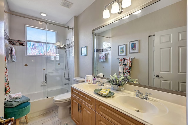 bathroom with double vanity, visible vents, toilet, and a sink