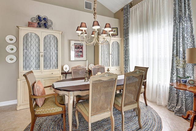 dining room featuring a chandelier, visible vents, light tile patterned floors, and vaulted ceiling