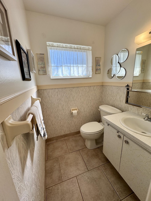 bathroom with tile patterned floors, vanity, toilet, and tile walls