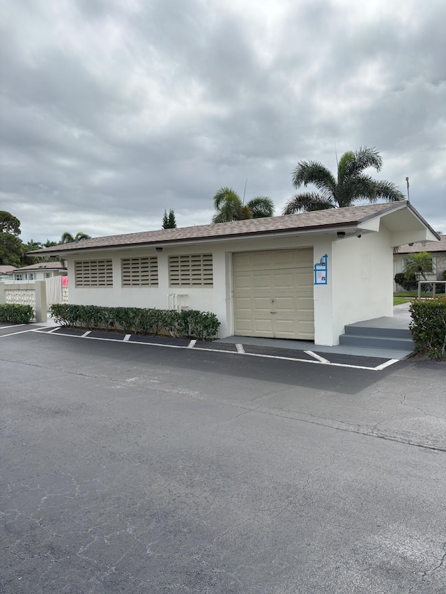 ranch-style house featuring a garage and stucco siding