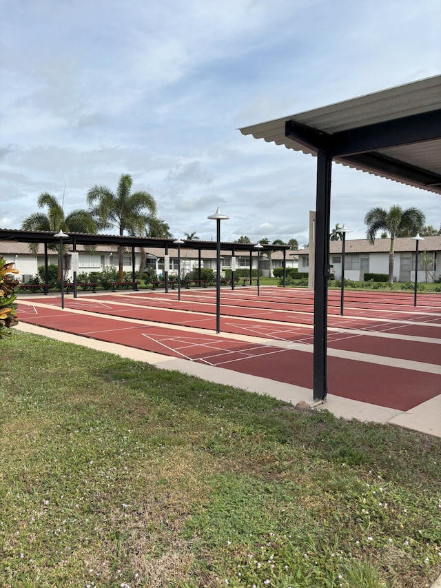 view of property's community featuring shuffleboard and a lawn