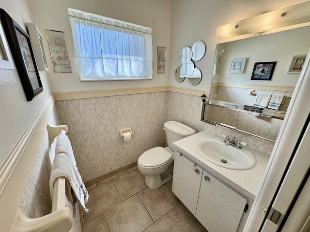 bathroom with tile patterned flooring, vanity, toilet, and tile walls