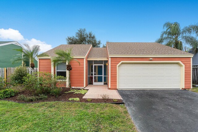 ranch-style home featuring a garage and a front lawn