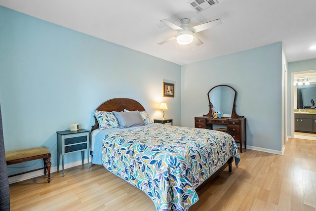 bedroom featuring ensuite bathroom, light wood-type flooring, ceiling fan, and sink