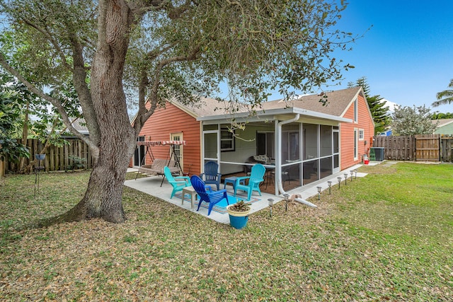 back of house with central air condition unit, a patio area, a lawn, and a sunroom