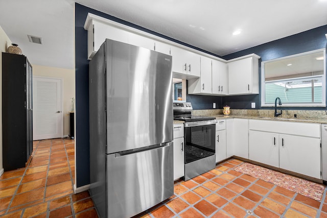 kitchen featuring appliances with stainless steel finishes, white cabinetry, and sink