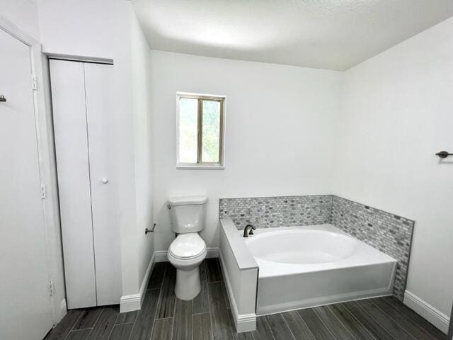 bathroom featuring a washtub and toilet