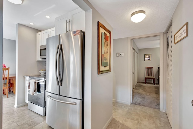 kitchen with white cabinets, appliances with stainless steel finishes, and a textured ceiling