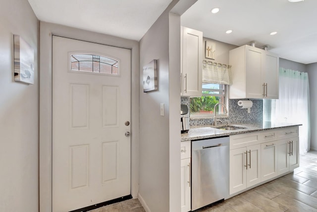 kitchen featuring white cabinetry, dishwasher, light stone countertops, and sink