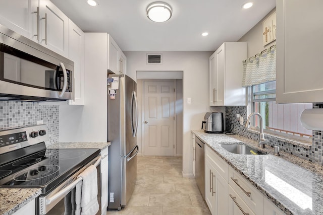 kitchen featuring light stone countertops, white cabinetry, sink, and stainless steel appliances