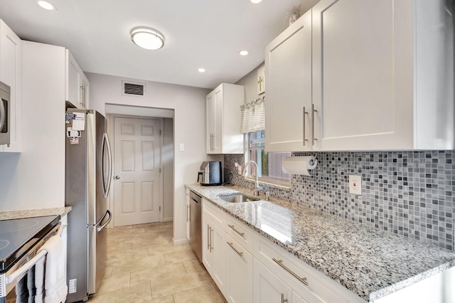 kitchen featuring tasteful backsplash, sink, white cabinets, and stainless steel appliances