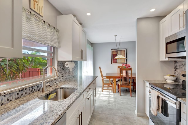 kitchen featuring white cabinets, pendant lighting, sink, and stainless steel appliances