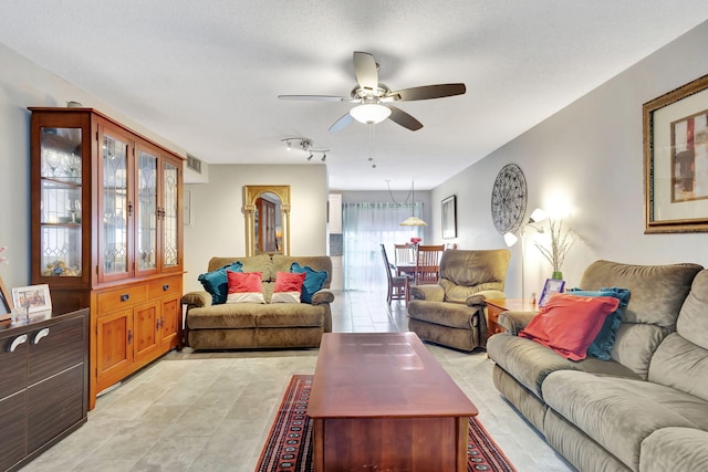 tiled living room featuring a textured ceiling and ceiling fan