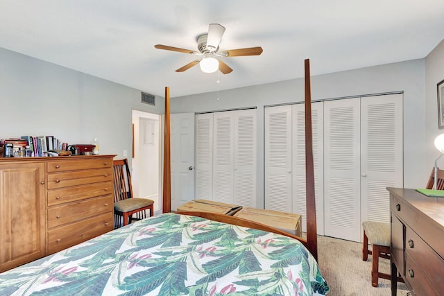 carpeted bedroom with two closets and ceiling fan