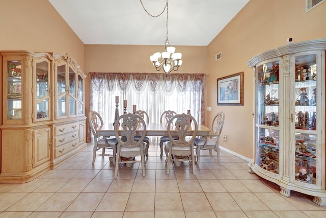 tiled dining space featuring lofted ceiling and an inviting chandelier