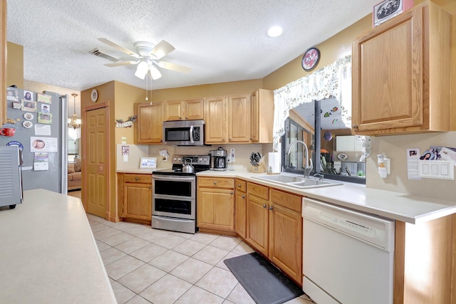 kitchen with light tile patterned flooring, sink, a textured ceiling, ceiling fan, and stainless steel appliances