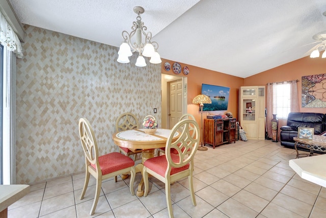 dining space featuring a notable chandelier, vaulted ceiling, a textured ceiling, and light tile patterned flooring