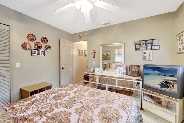 bedroom with ceiling fan, a closet, and a textured ceiling