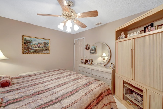 bedroom with ceiling fan and a textured ceiling