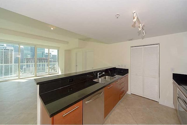 kitchen with dishwasher, light tile patterned floors, and sink