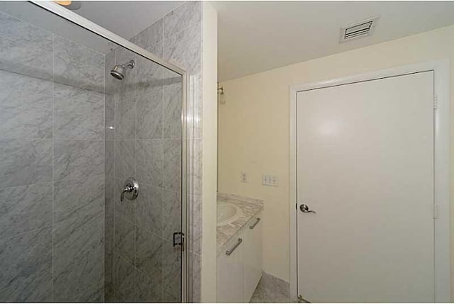 bathroom featuring vanity and an enclosed shower