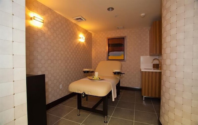 sitting room featuring dark tile patterned flooring and sink