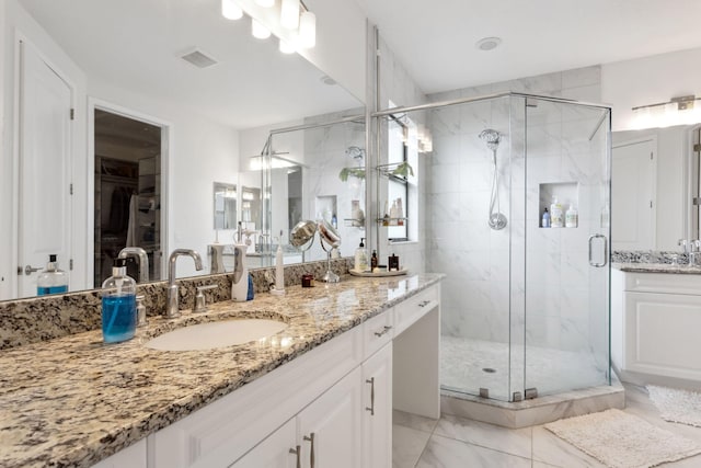 bathroom featuring vanity and a shower with door