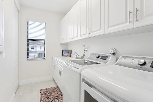 laundry room featuring cabinets, separate washer and dryer, light tile patterned floors, and sink