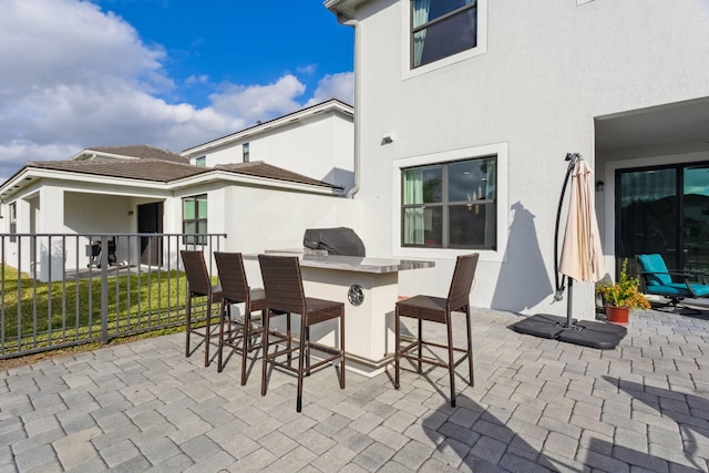 view of patio / terrace featuring an outdoor kitchen, an outdoor bar, and a grill