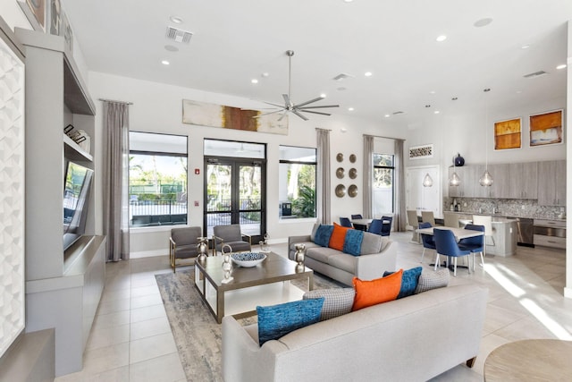 tiled living room featuring ceiling fan and french doors