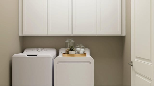 laundry room with washing machine and dryer and cabinets