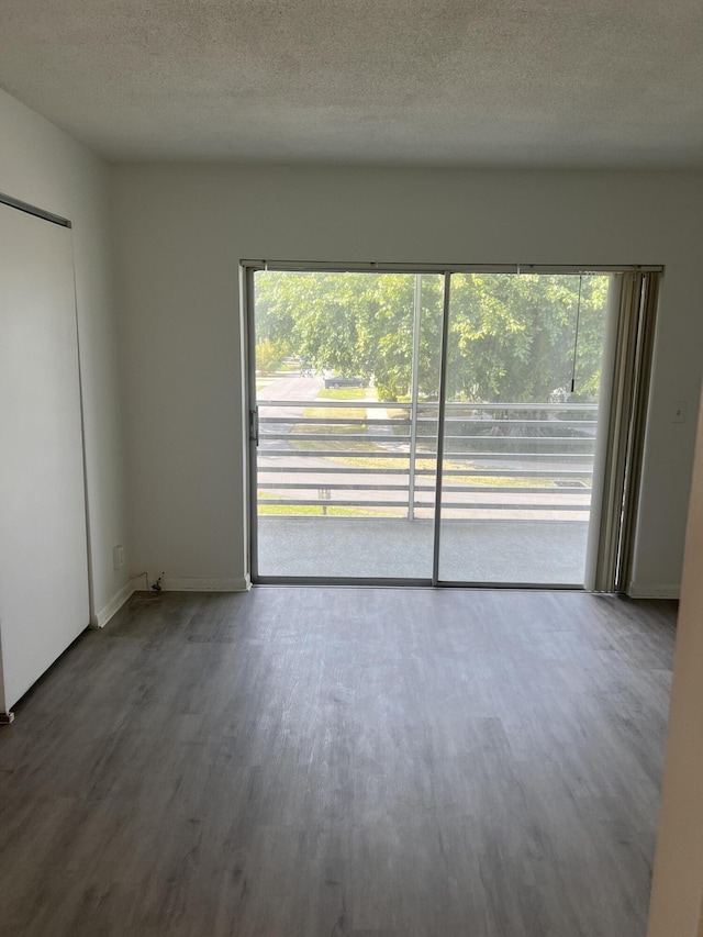 unfurnished room featuring hardwood / wood-style floors, a textured ceiling, and a healthy amount of sunlight