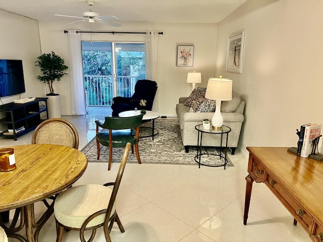 living room featuring light tile patterned floors, ceiling fan, and baseboards