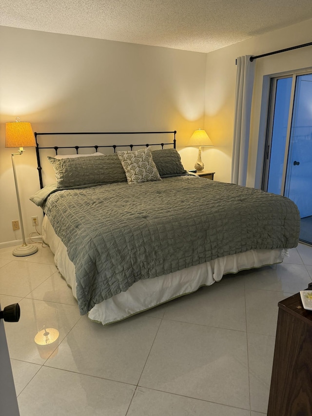 bedroom with tile patterned flooring, a textured ceiling, and access to exterior