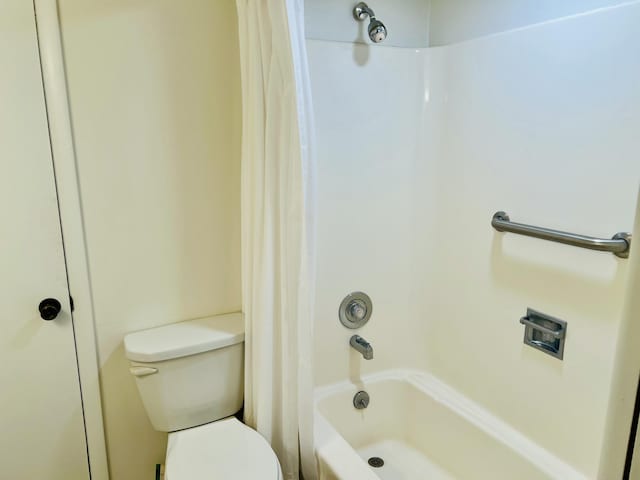 bathroom featuring shower / bath combo and toilet