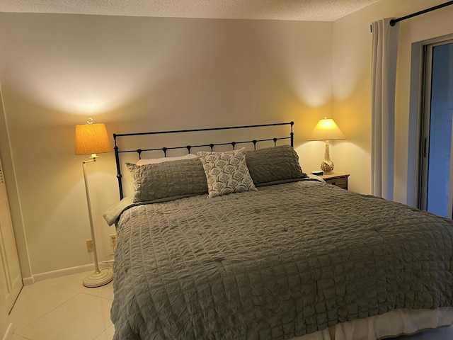 bedroom with light tile patterned floors and a textured ceiling