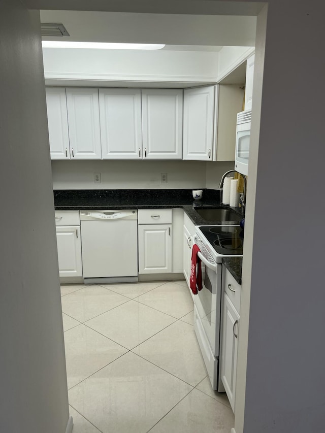 kitchen with white cabinets, light tile patterned floors, white appliances, and sink