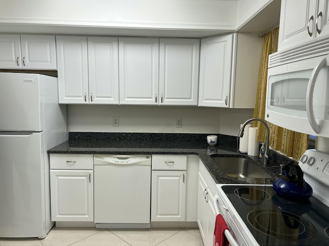 kitchen with white cabinets, light tile patterned flooring, and white appliances