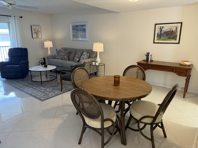 dining room with ceiling fan, light tile patterned floors, and a textured ceiling