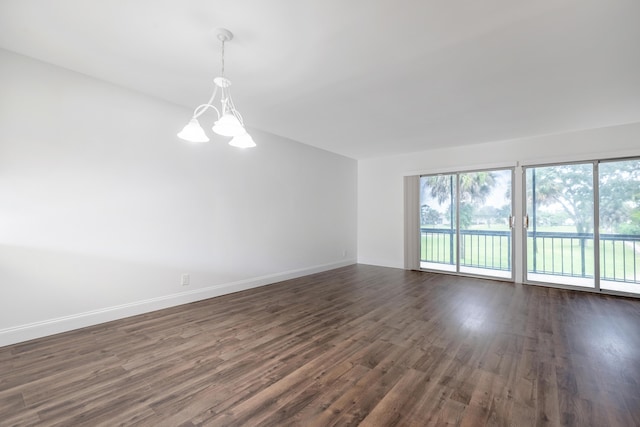 unfurnished room featuring dark hardwood / wood-style flooring and a chandelier